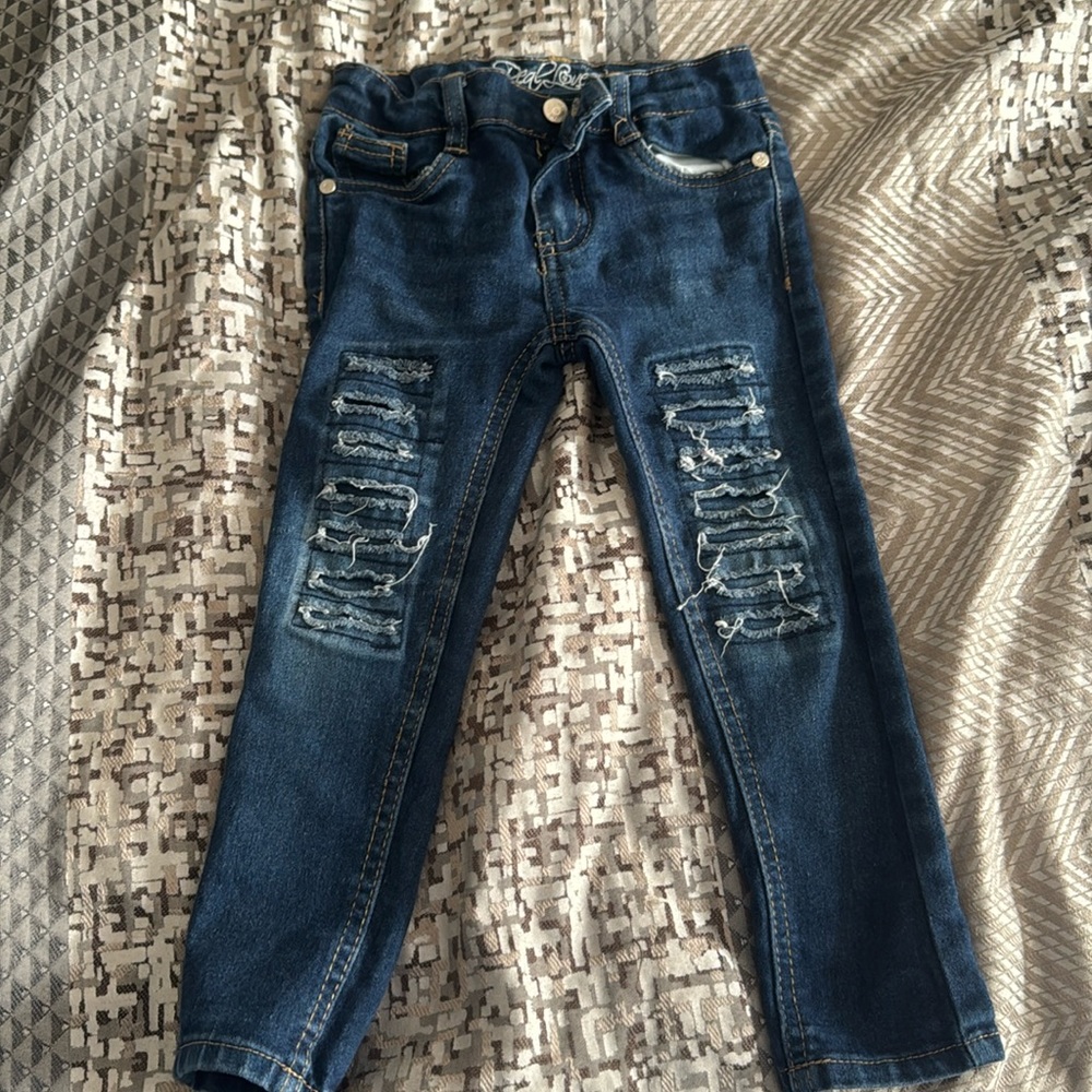 Skinny leg deconstructed jeans with light brown stitch